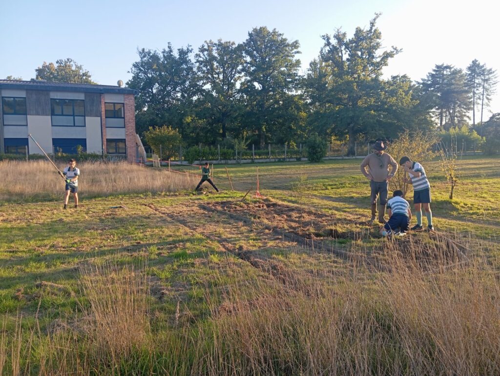 Élèves défrichant l’ancien potager pour les premiers semis